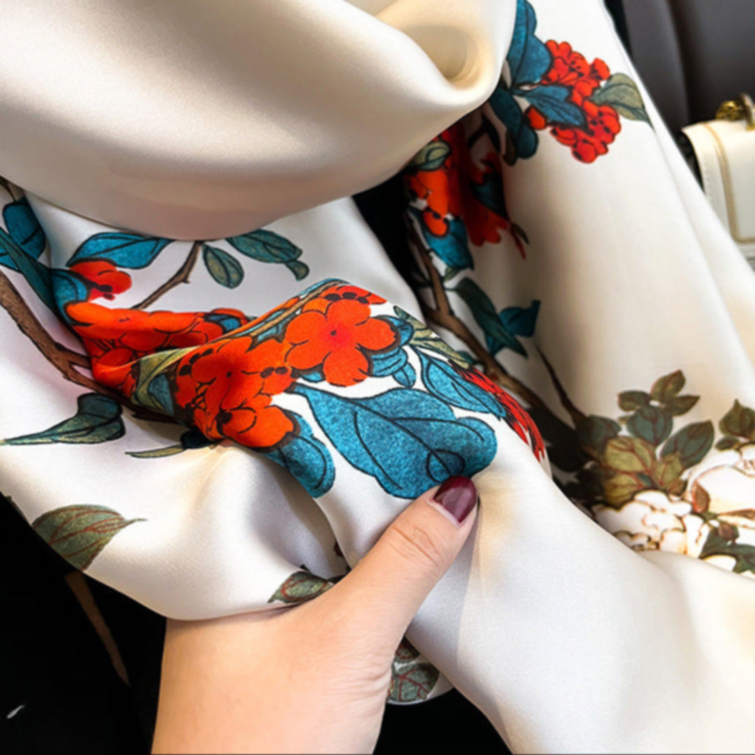 Close-up of a floral-patterned scarf with a hand holding it