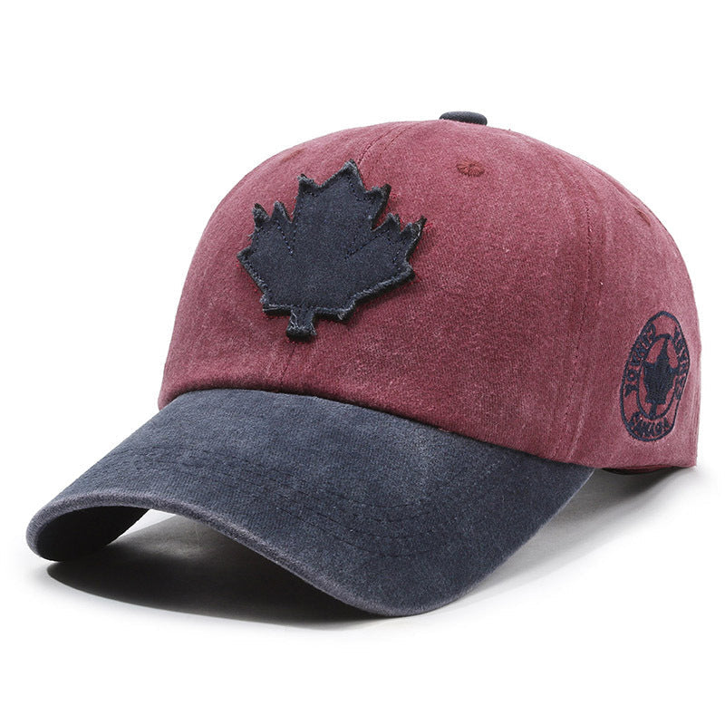Two-toned cap with a black maple leaf design on a white background